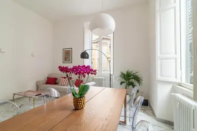 a dining room with a table with purple flowers on it at Aureliana luxury apartment in Rome