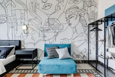 a bedroom with a blue couch in front of a mural at BDC - Rome with a view! in Rome
