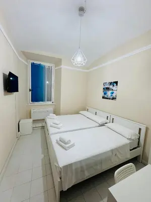 a white room with two beds and a window at MILLE PARADISO in Rome