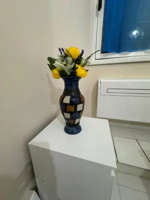 a vase with yellow flowers sitting on a white cabinet at MILLE PARADISO in Rome