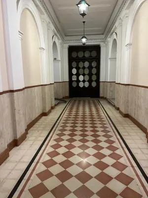 an empty hallway with a black door and a checkerboard floor at MILLE PARADISO in Rome