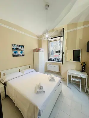 a bedroom with a large white bed and a window at MILLE PARADISO in Rome