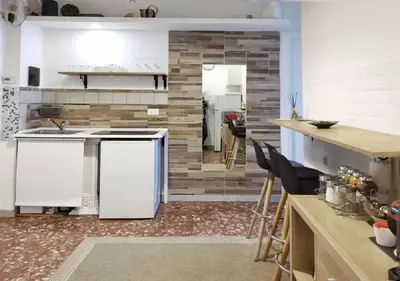 a kitchen with white appliances and a wooden wall at 