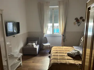 a bedroom with a bed and a chair and a window at Giuliana Vatican Luxury Home in Rome