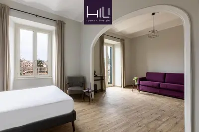 a bedroom with a bed and a purple couch at Colosseo Road by Hili in Rome