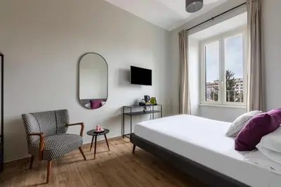 a bedroom with a bed and a chair and a mirror at Colosseo Road by Hili in Rome