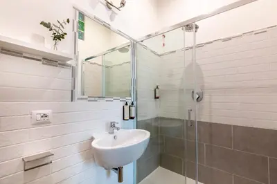 a white bathroom with a sink and a shower at Colosseo Road by Hili in Rome