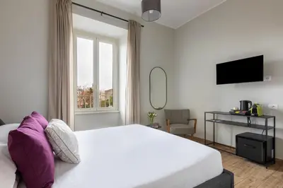 a bedroom with a large white bed and a window at Colosseo Road by Hili in Rome