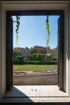 an open door with a view of a field at FUORI dal TEMPO Roma Trastevere in Rome