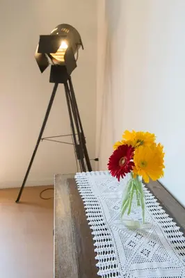 a vase of flowers sitting on a table with a camera at FUORI dal TEMPO Roma Trastevere in Rome