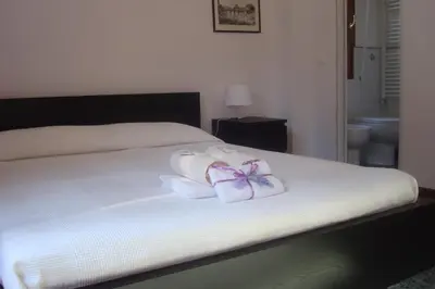 a bedroom with a bed with two rolled towels at Apartment Bruno's in Rome
