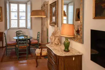 a living room with a table and a lamp on a cabinet at Farnese Apartment Navona Historic Center in Rome