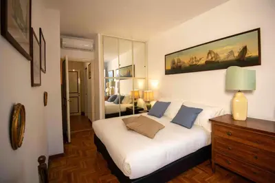 a bedroom with a large white bed with blue pillows at Farnese Apartment Navona Historic Center in Rome