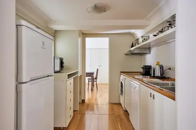 a kitchen with white appliances and a wooden floor at iFlat Retro Chic Apartment in Prati in Rome