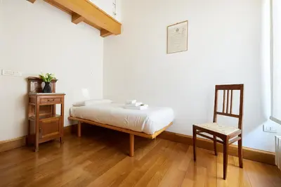 a bed in a room with a chair and a table at iFlat Retro Chic Apartment in Prati in Rome