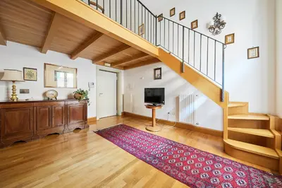 a living room with a staircase and a red rug at iFlat Retro Chic Apartment in Prati in Rome