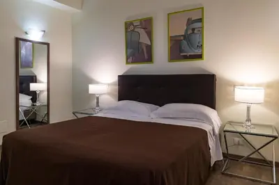 a bedroom with a large bed with two lamps at B&B Residenza Gregorio VII in Rome