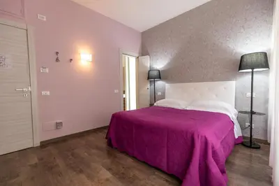 a bedroom with a large bed with a purple blanket at B&B Residenza Gregorio VII in Rome
