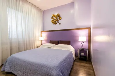 a bedroom with a large bed and two lamps at B&B Residenza Gregorio VII in Rome