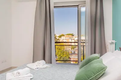 a bedroom with a bed and a balcony with a view at 2-Bedroom Retreat near Metro & Parks in Rome