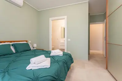 a bedroom with a green bed with towels on it at 2-Bedroom Retreat near Metro & Parks in Rome