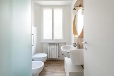 a white bathroom with two toilets and a sink at LoveRhome Apartment 1 in Rome