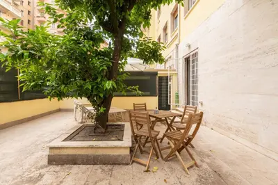 a table and chairs under a tree in a courtyard at LoveRhome Apartment 1 in Rome