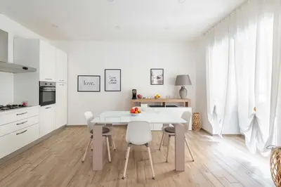 a white kitchen with a white table and chairs at LoveRhome Apartment 1 in Rome