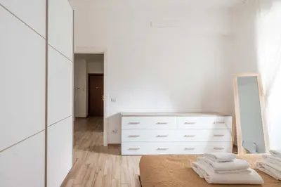 a white bedroom with a dresser and a mirror at LoveRhome Apartment 1 in Rome