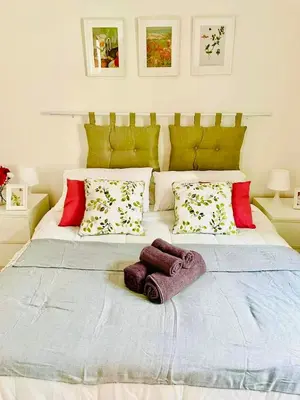 a white dining room table with red flowers on the wall at Holiday Homes Rome - Monte Verde 61 - near Trastevere in Rome