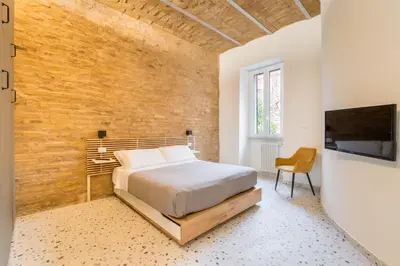 a bedroom with a bed and a flat screen tv at FAMM Apartments - Open space in Trastevere in Rome