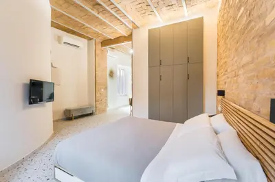 a bedroom with a white bed and a brick wall at FAMM Apartments - Open space in Trastevere in Rome