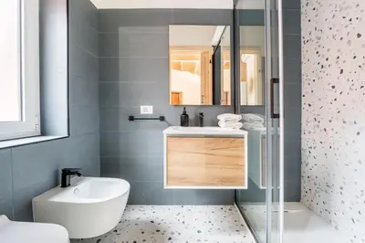 a bathroom with a sink and a toilet and a mirror at FAMM Apartments - Open space in Trastevere in Rome
