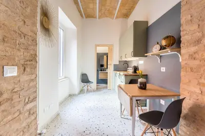 a kitchen and dining room with a table and chairs at FAMM Apartments - Open space in Trastevere in Rome