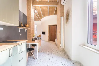 a kitchen with a table and a desk in a room at FAMM Apartments - Open space in Trastevere in Rome