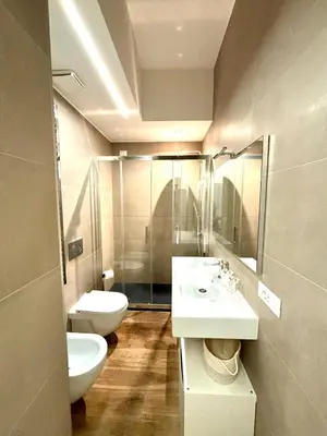 a bathroom with two sinks and a toilet and a mirror at Matilda House EUR 4 posti letto in Rome