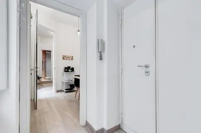 a hallway with white walls and a glass door at Classy 2-bdr in Termini district in Rome