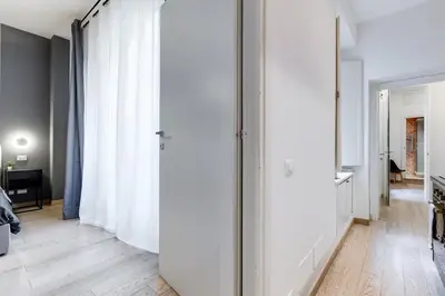 a hallway with white walls and a floor to ceiling window at Classy 2-bdr in Termini district in Rome