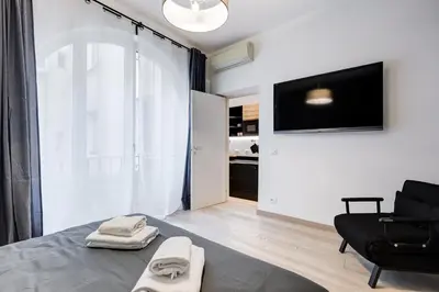 a bedroom with a bed and a chair and a television at Classy 2-bdr in Termini district in Rome