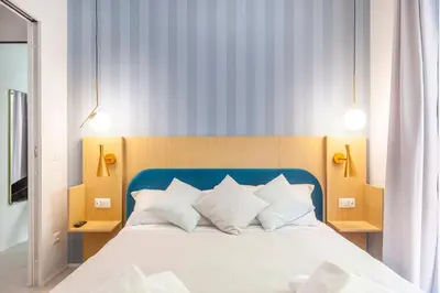 a bed with a blue headboard and white pillows at Mom's home - A few stops from the city centre in Rome