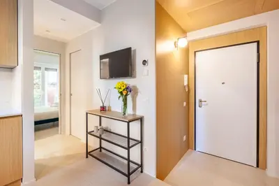 a hallway with a door and a vase of flowers on a table at Mom's home - A few stops from the city centre in Rome