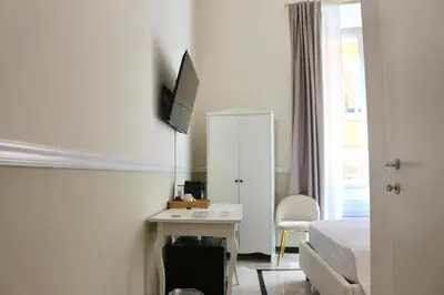 a bedroom with a bed and a desk with a television at Hotel Domus Rome in Rome