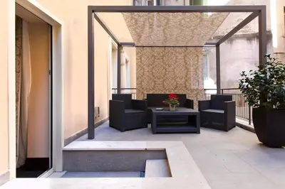 a patio with chairs and a table on a balcony at Quirinale Luxury Rooms in Rome