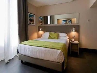 a bedroom with a large bed with a green blanket at Quirinale Luxury Rooms in Rome