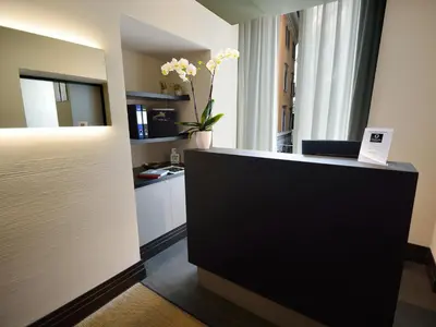 a room with a reception desk with a vase of flowers at Quirinale Luxury Rooms in Rome