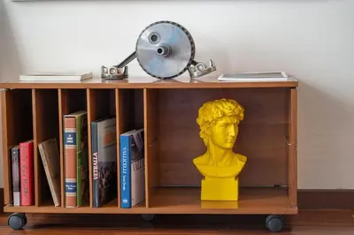 a desk with a bust and a lamp and books at PgrHome Barberini in Rome