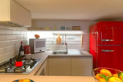 a kitchen with a red refrigerator and a sink at Saint Louis Penthouse, cozy little apartment next to Pantheon in Rome