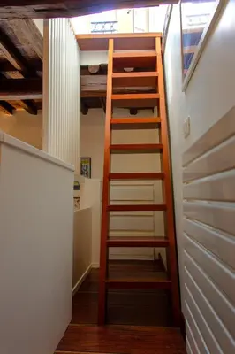 a ladder leading up to a loft in a house at Saint Louis Penthouse, cozy little apartment next to Pantheon in Rome