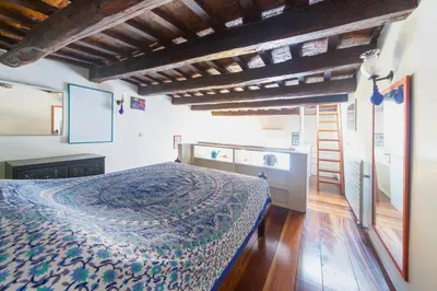 a bedroom with a bed in a room with wooden floors at Saint Louis Penthouse, cozy little apartment next to Pantheon in Rome