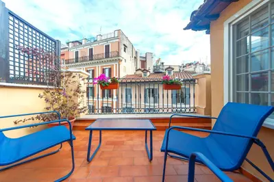 a balcony with two chairs and a table on a balcony at Saint Louis Penthouse, cozy little apartment next to Pantheon in Rome